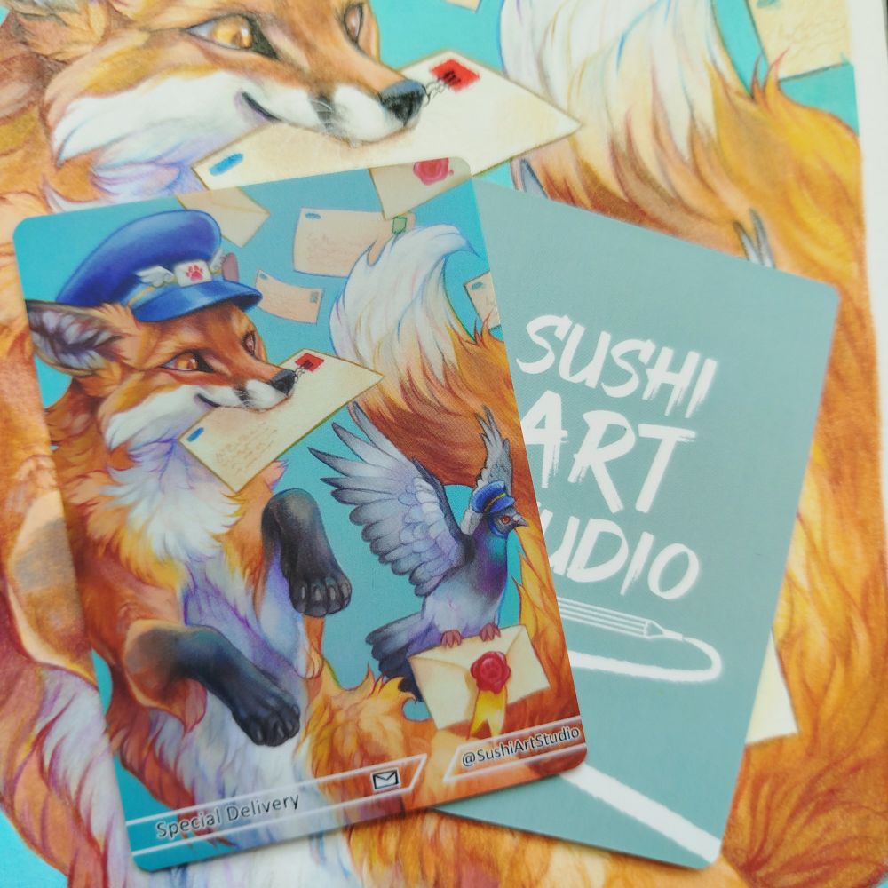 Two trading cards showing front and back images. One side has an image of a fox and pigeon delivering mail and the other side has a SushiArtStudio logo. The cards are placed ontop of a larger drawing of the same image.
