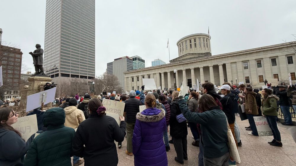 Photo of many people at a rally in front of a government building
