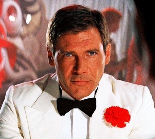 Harrison Ford as Indiana Jones in a white suit with red flower in "Indiana Jones and the Temple of Doom."