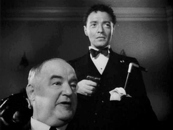 Kasper Gutman (Sydney Greenstreet) backed up by Joel Cairo (Peter Lorre) with gun and cane