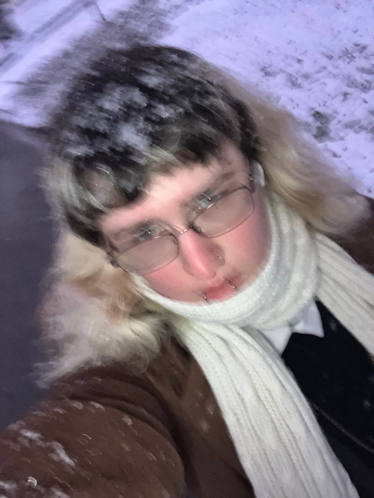 blurry photo of nonbinary walking in the snow