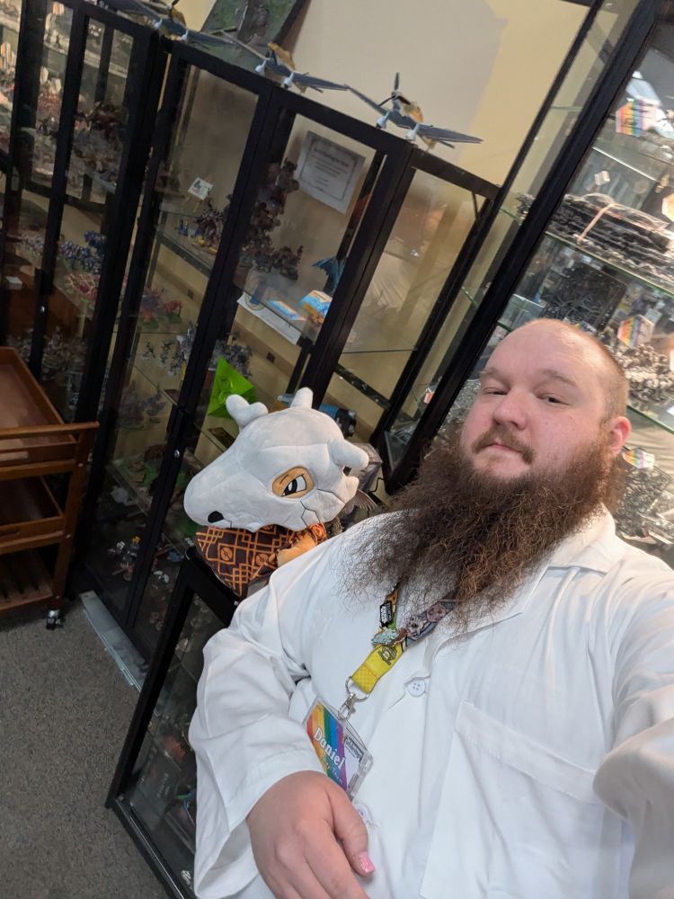 Daniel in a lab coat, with a Cubone plush. 