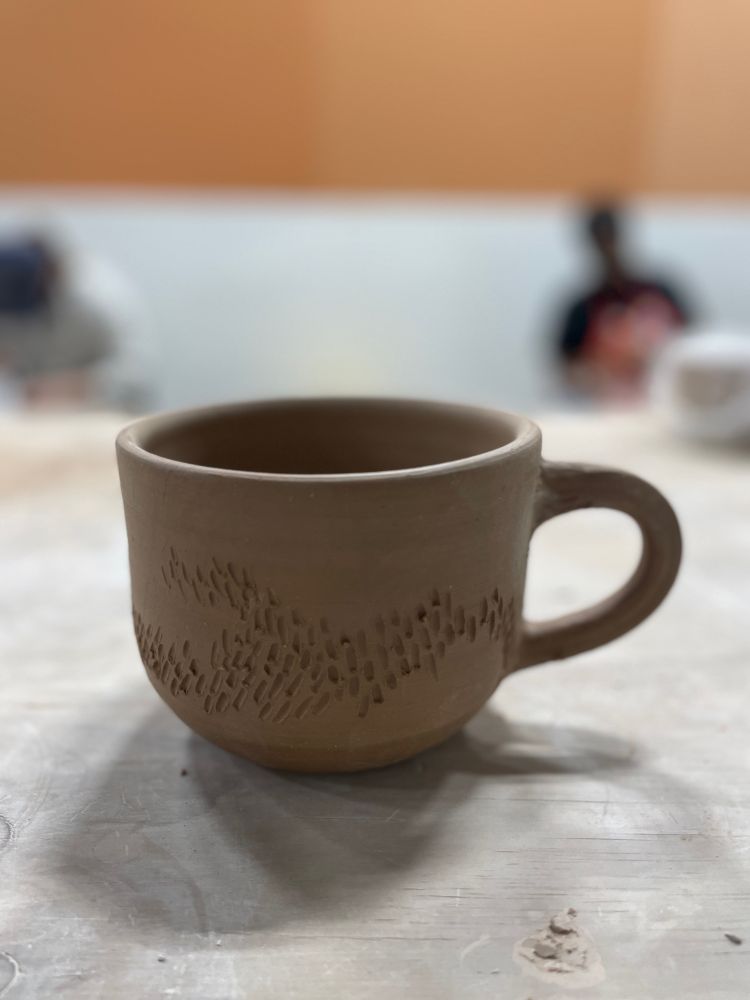 Large soup mug in dark clay body with surface carving