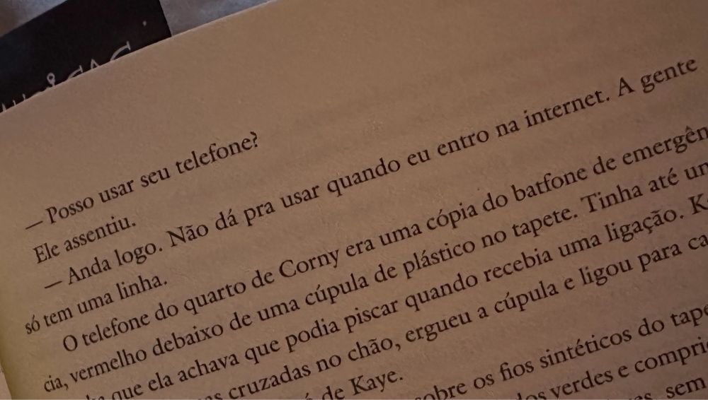 Foto de uma página de livro com os dizeres “- Posso usar seu telefone?” “- Anda logo. Não dá pra usar quando eu entro na internet. A gente só tem uma linha.”