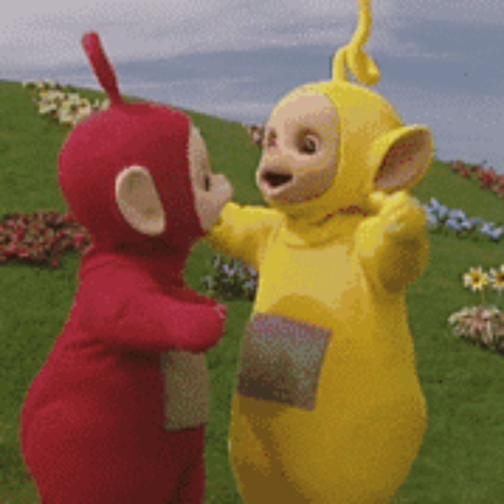 two teletubbies are hugging each other in a field