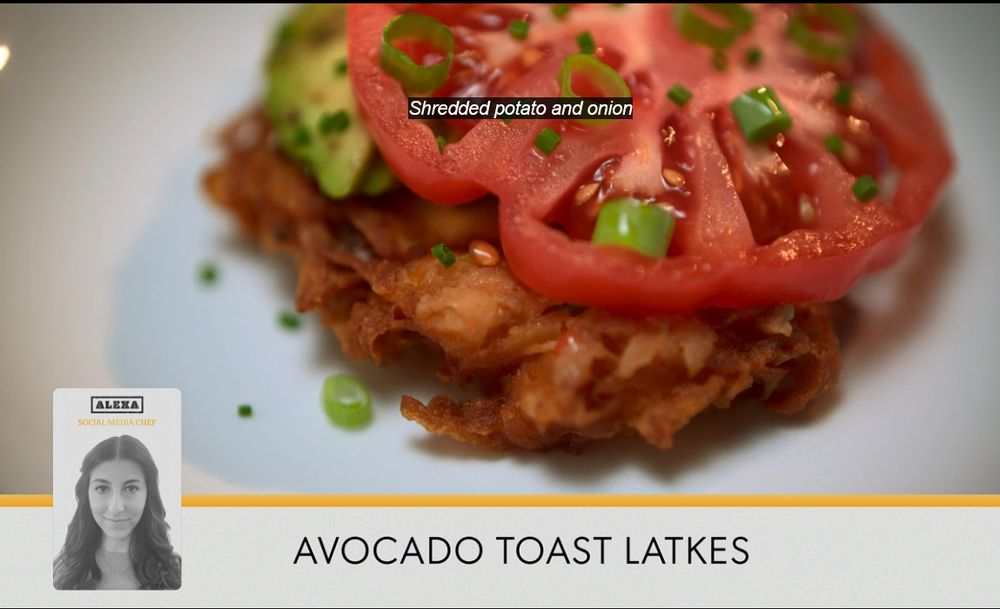 a screenshot of a show from a cooking competition, the words "avocado toast latkes" are at the bottom underneath a crispy potato latke topped with smashed avocado, a gorgeous slice of tomato, and chives. It looks delicious. There is a small black and white picture of the chef who made it labeled with her name (Alexa). 