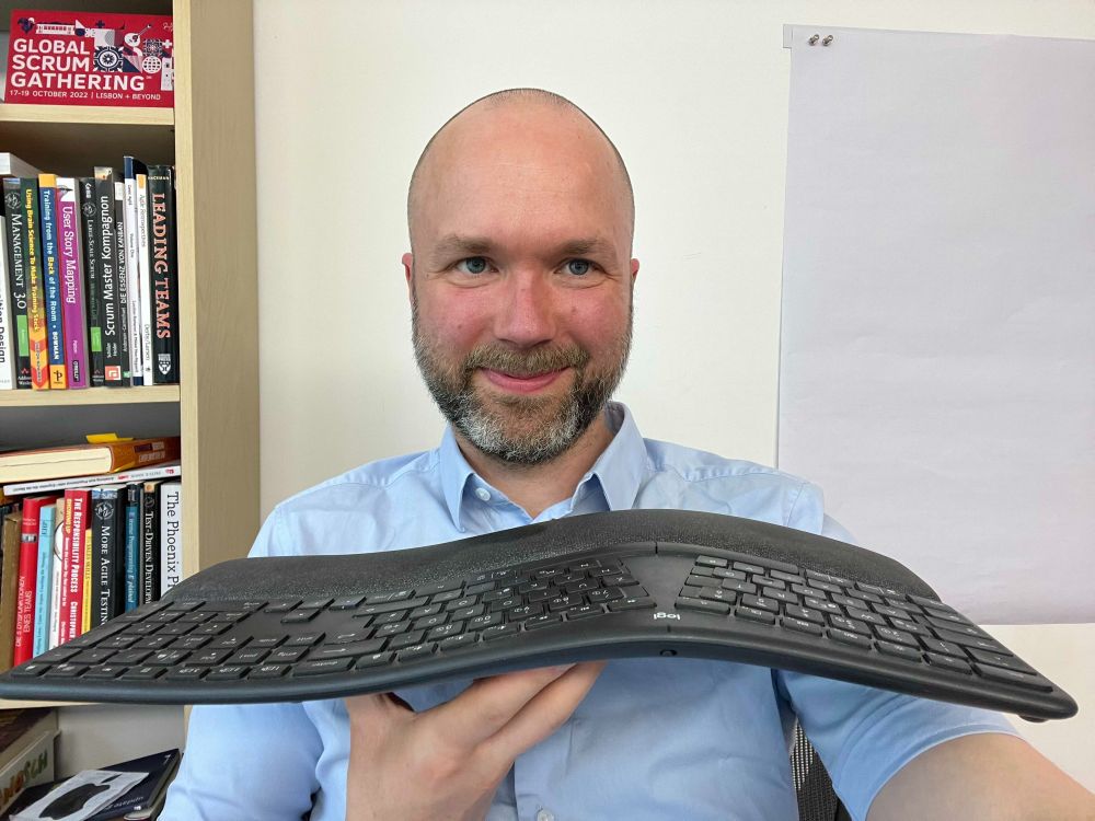 Timon Fiddike mit Tastatur als Symbol für Coding.