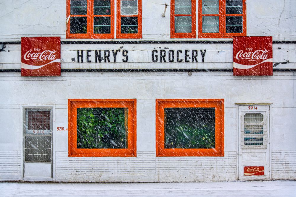 Henry's Grocery in heavy snow with many plants in the windows. 