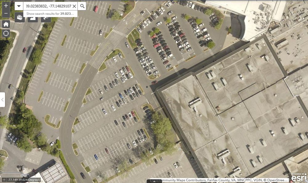 Satellite image of surface parking lots around an enclosed shopping mall.