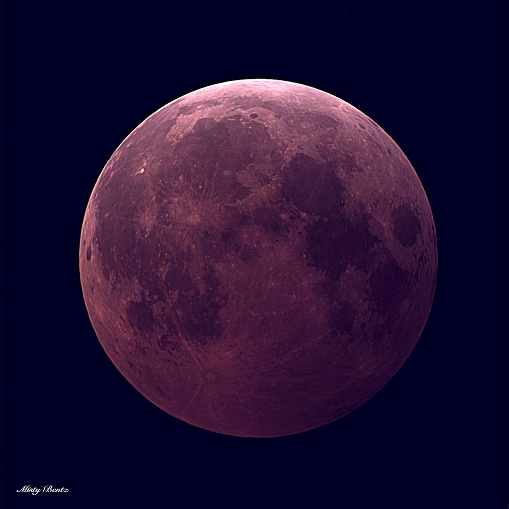 An image of the full moon during totality of the lunar eclipse.  The moon is much darker than usual and a lovely rusty red color.