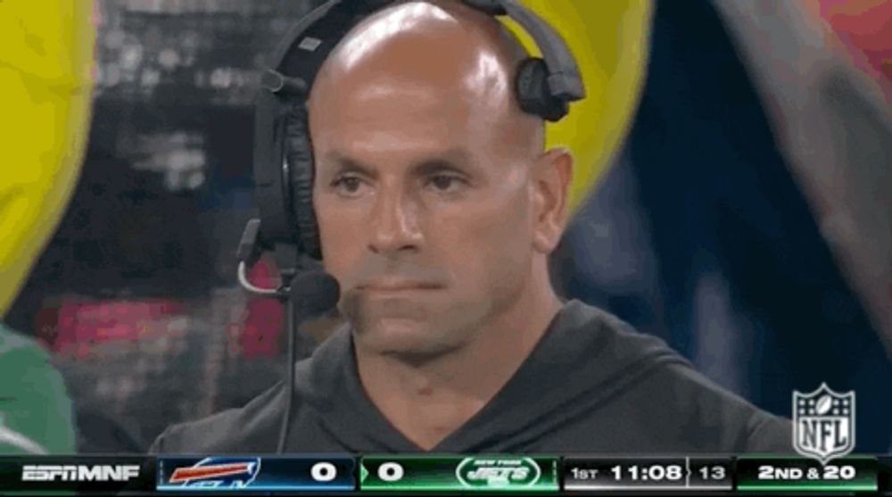 a man wearing a headset is watching a football game on espn