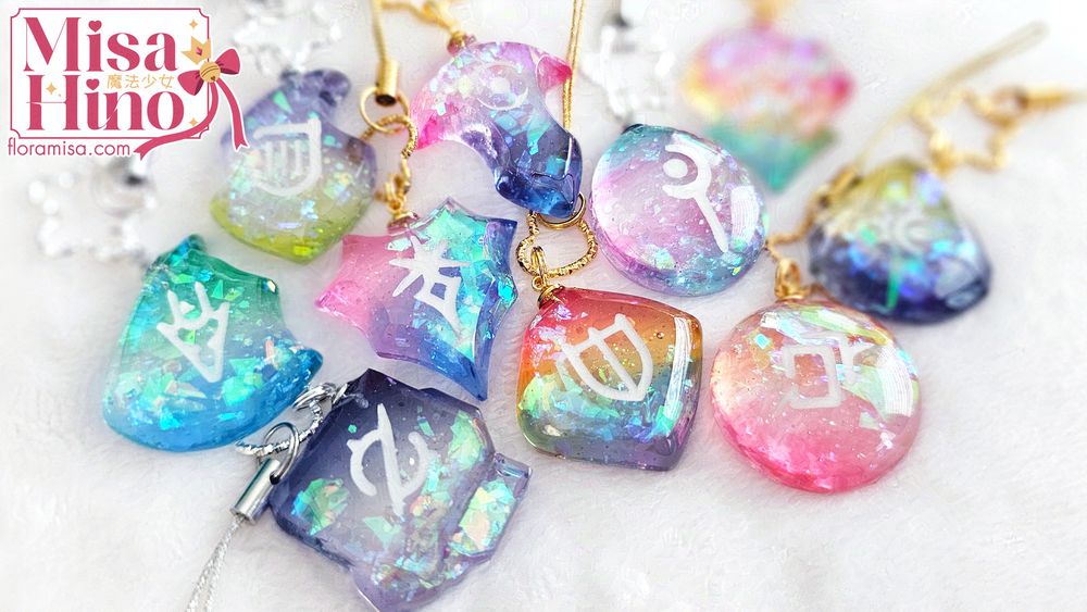 Various custom Final Fantasy XIV resin job stones in pride themed colors.