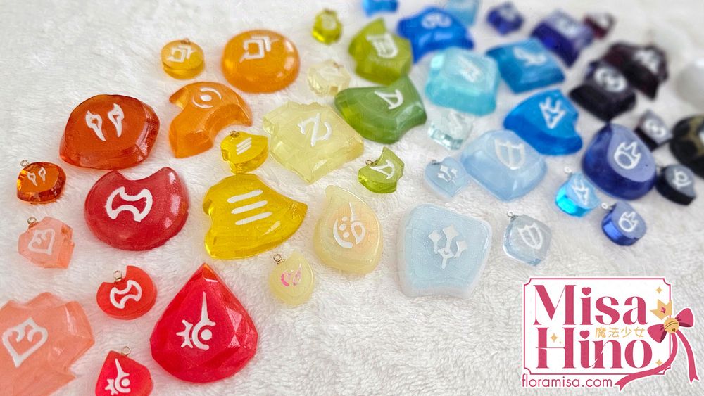 Various Final Fantasy XIV resin job stones arranged in rainbow order.