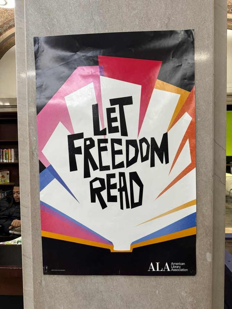 A poster by the American Library Association illustrating an open book with the words Let Freedom Read on the pages. 