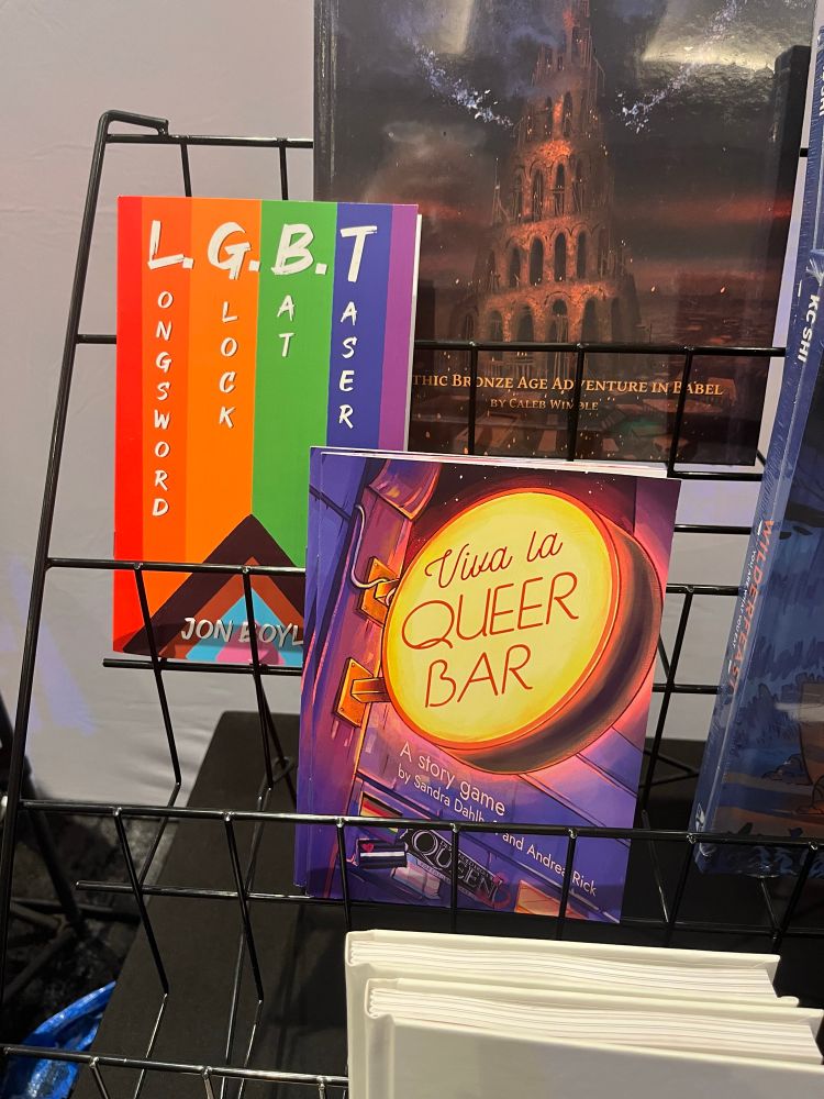 Pictures of the games “Viva la Queer Bar”  and “L.ongsword G.lock T.aser B.at”