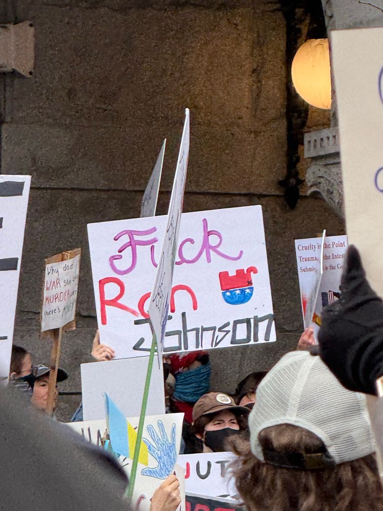 Protestor holding a sign that says FUCK RON JOHNSON