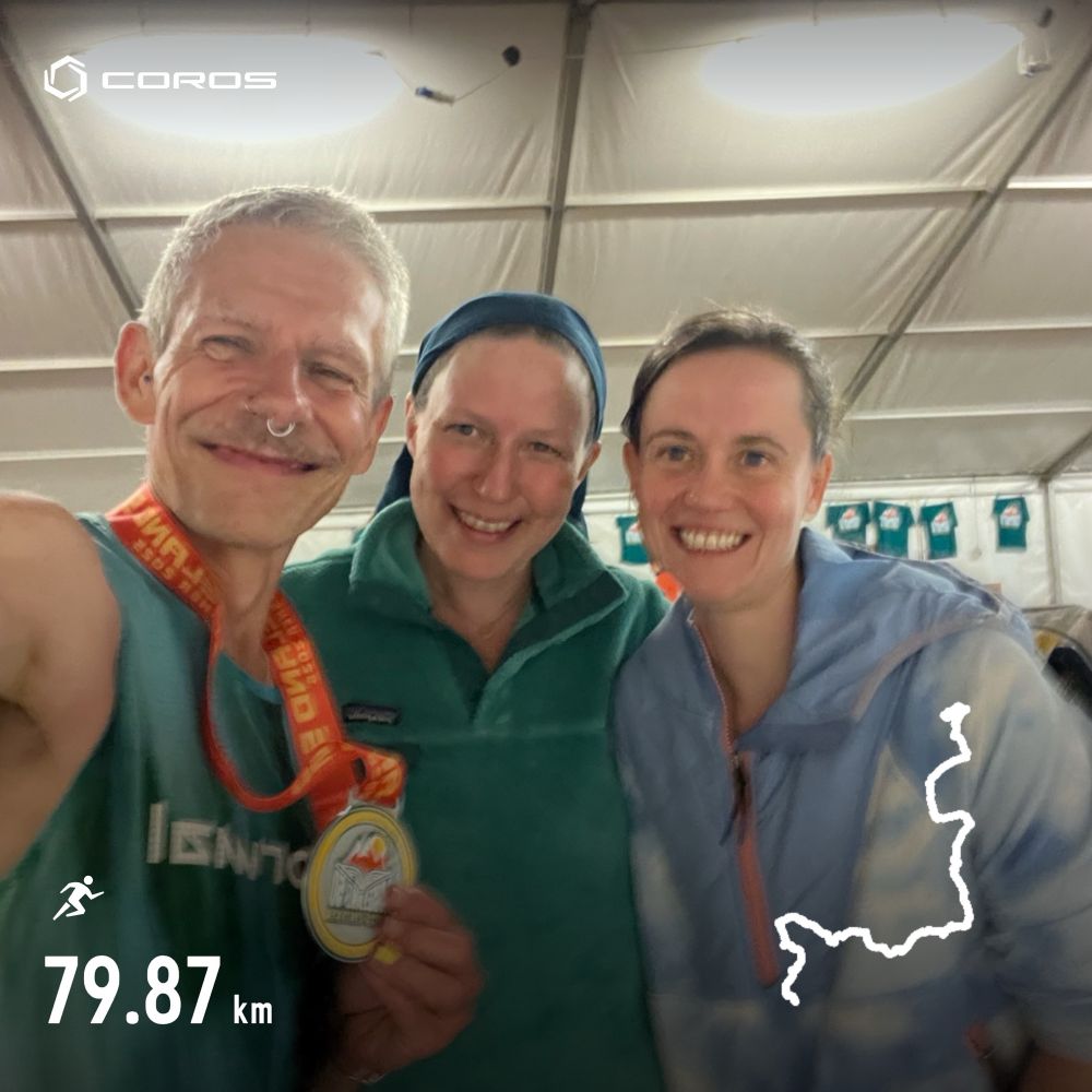 Anson holding up their race medal, taking selfie with two friends 