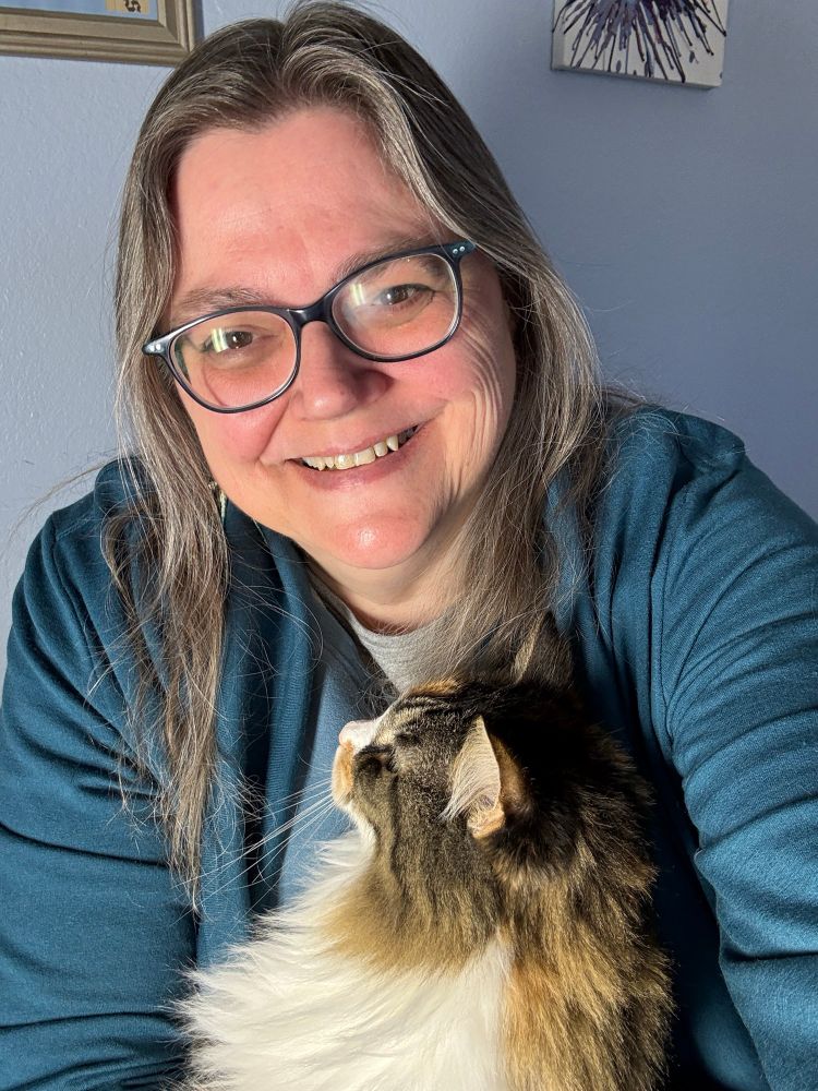 Photo of Sally smiling and holding her long-haired cat