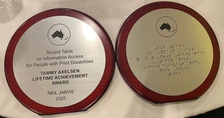 Neil’s award. It is an opening disk with the left side in print and the right side in braille naming him winner for 2025.