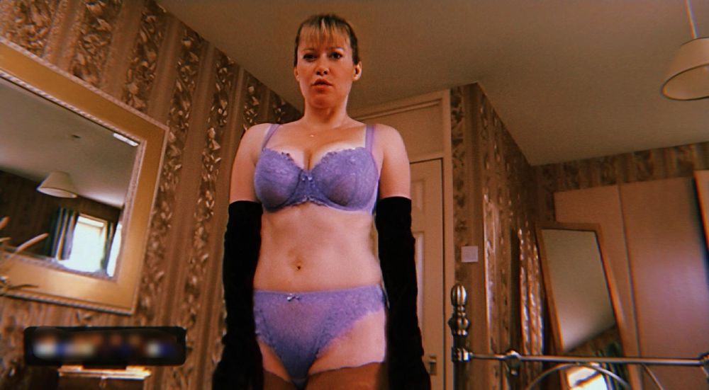 Actress Maggie O’Neil playing Sheila in Shameless wearing lilac lacy underwear in a slightly shabby bedroom