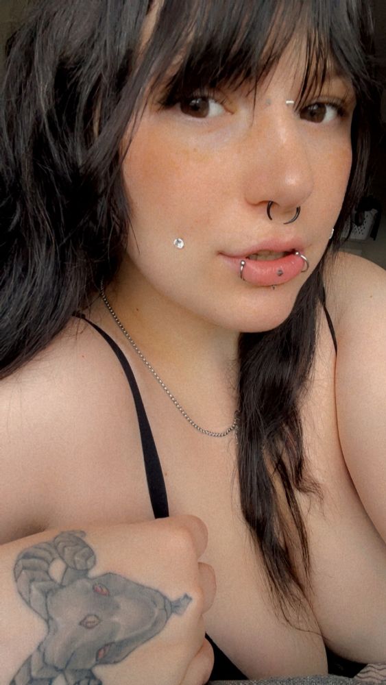 Mommy Sammy posing for the camera, her big brown honey eyes staring into the lens. Her hand tattoo of Billy Baphomet is exposed and her piercings are shiny and pretty on her face.