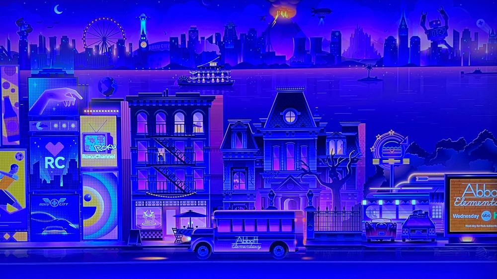 An Abbott elementary school bus drives through the Roku city screensaver