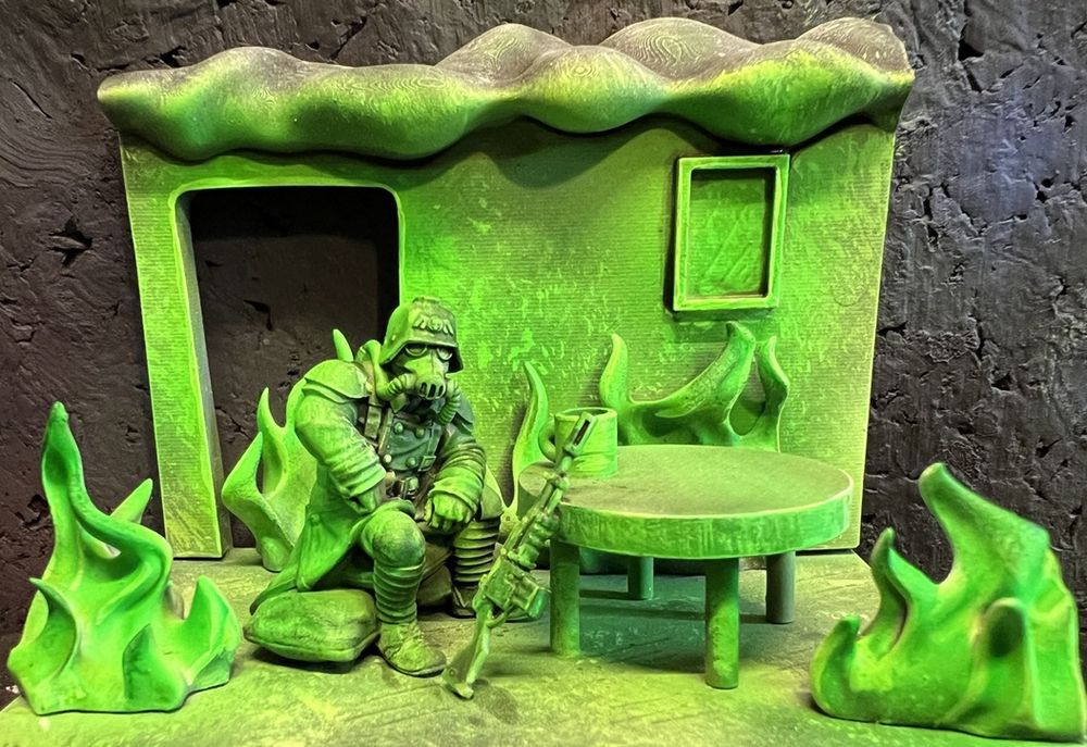 Kreig Guardsman sitting at a table in a room which appears to be on fire with green witch light
