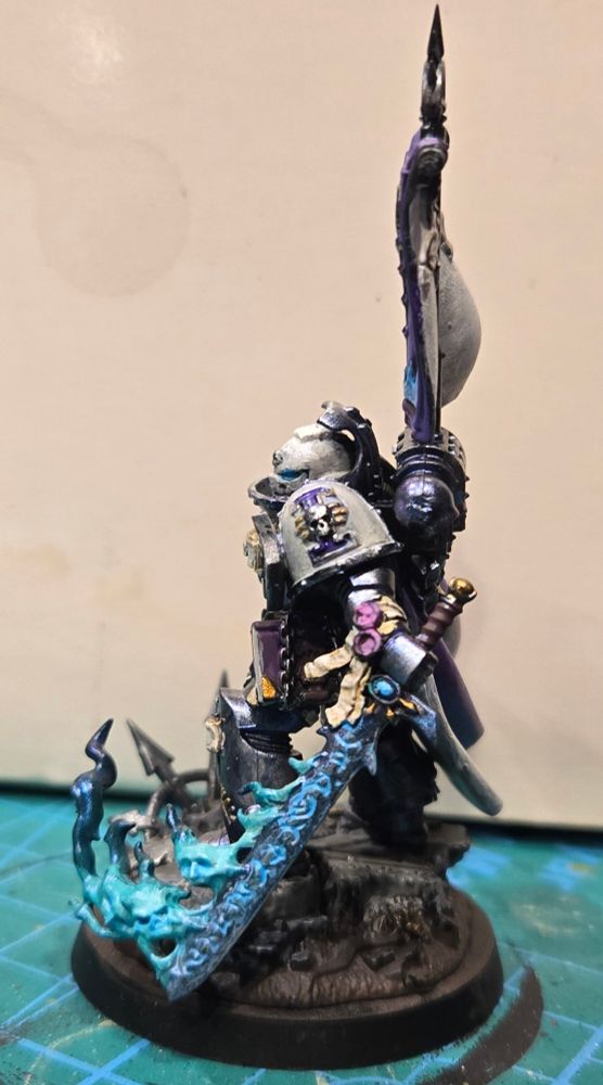 Castellan Crowe in a very fine Purple silken cape with his famous seafoam flaming demon sword. His silver armor has a purple/blue shimmer and his white helmet and shoulders have a pearlescent sheen.