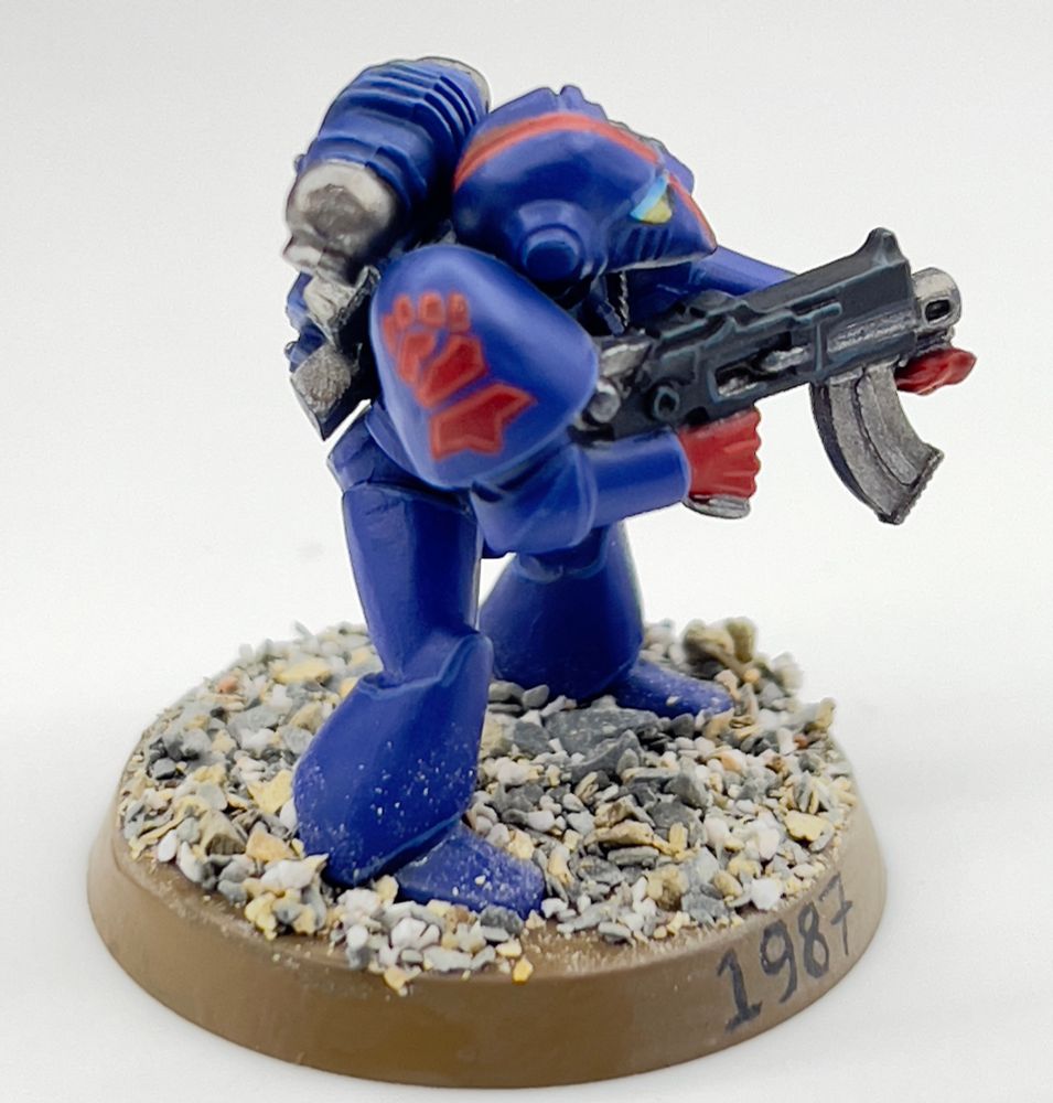 A rogue trader era space marine from the crimson fist chapter
He’s blue with red hands and  chapter symbol