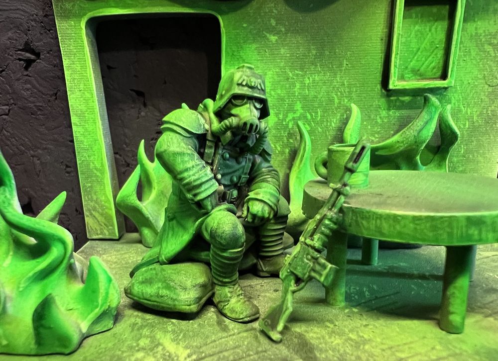 Kreig Guardsman sitting at a table in a room which appears to be on fire with green witch light