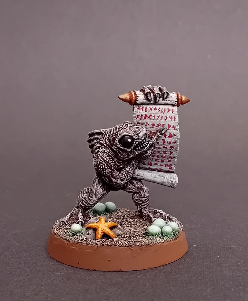 Squesh pointing to his scroll list. It is written in blood. How this dried under the sea is a mystery that will not be revealed to you. There are glowing green eggs at his feet and he is accompanied by his starfish companion, Sebastian.