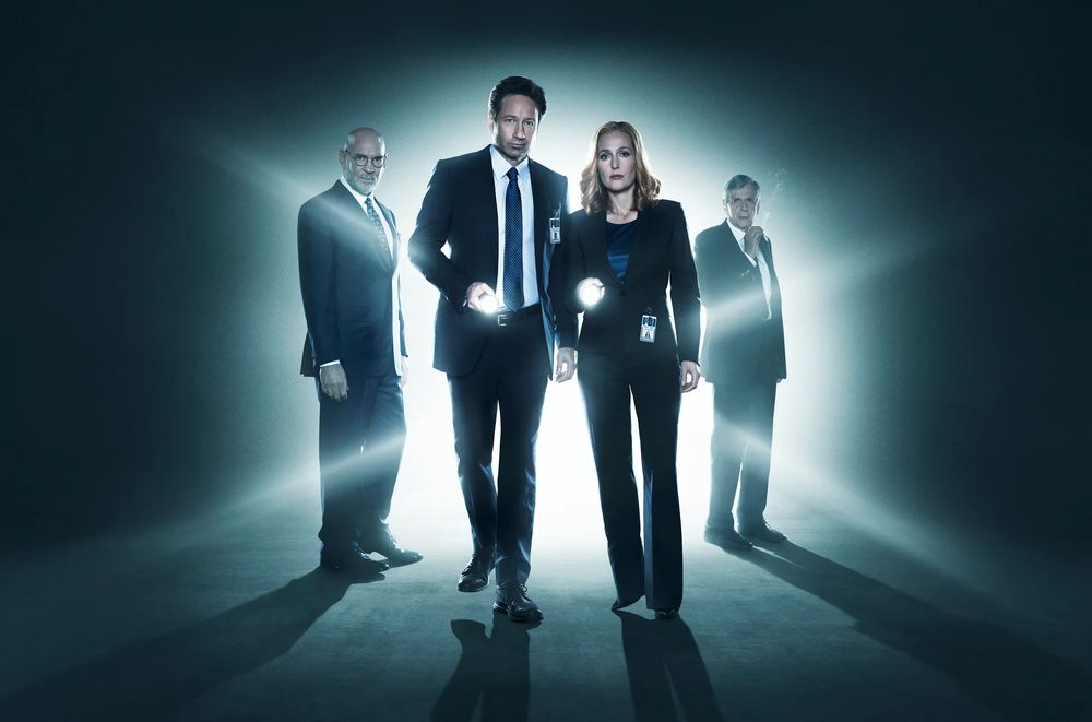 Dark-yet-glowy promo pic for The X-Files. Mulder and Scully in the foreground with flashlights, Skinner and the CSM kinda looming behind them.