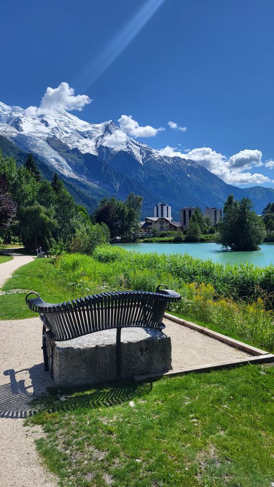 湖のそばにあったオシャレなベンチ
写真のバックグラウンドに白い山が見える。青空と白い雲が綺麗