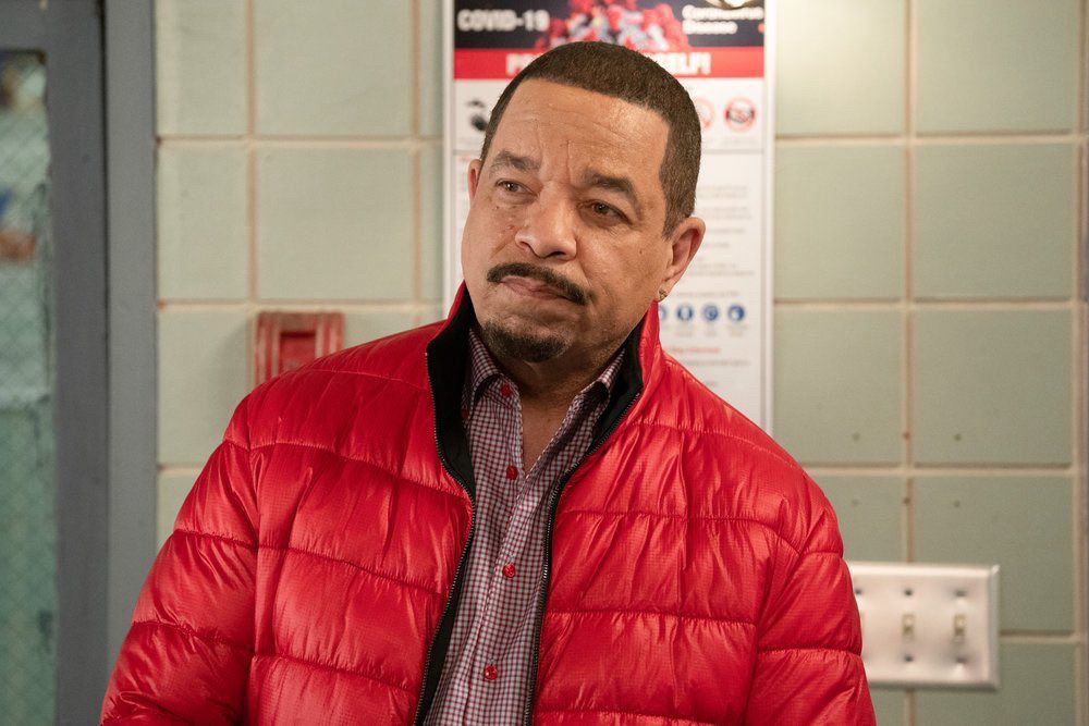 Ice-T squints at someone off-camera while wearing a red bubble puffer coat