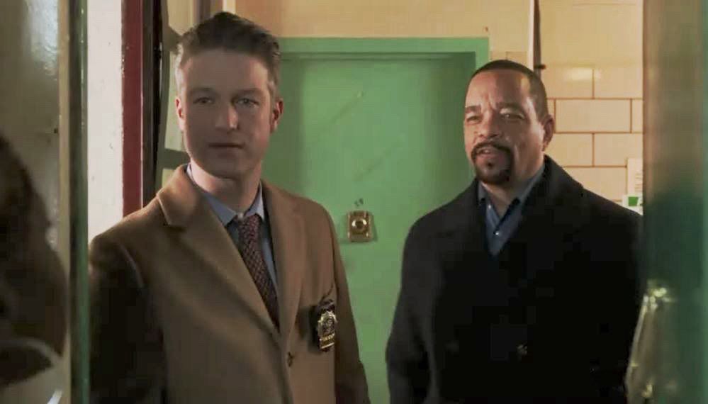 Ice-T and his detective buddy stand in the doorway of an apartment and stare incredulously at someone inside 