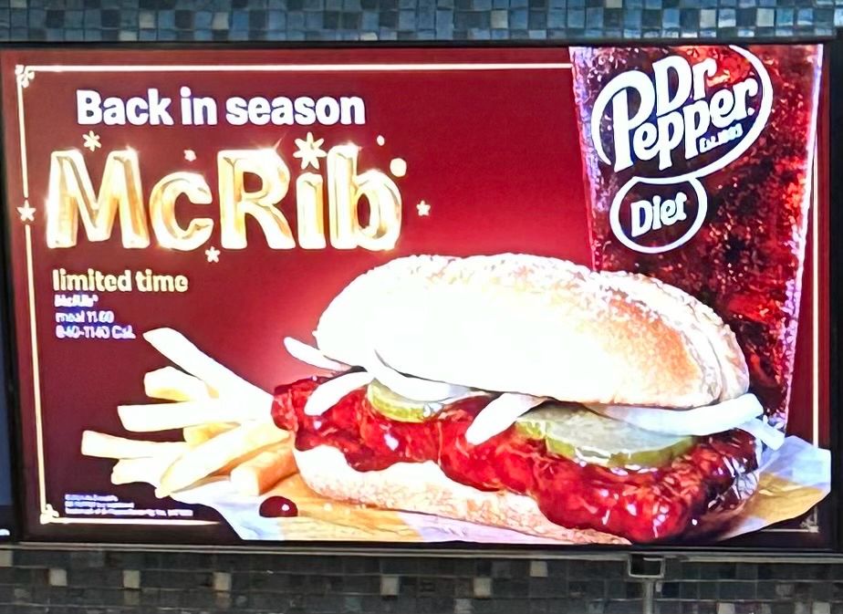 Picture of a McDonald’s screen showing that it’s a McRib season with a picture of the McRib sandwich, fries , and a Dr. Pepper