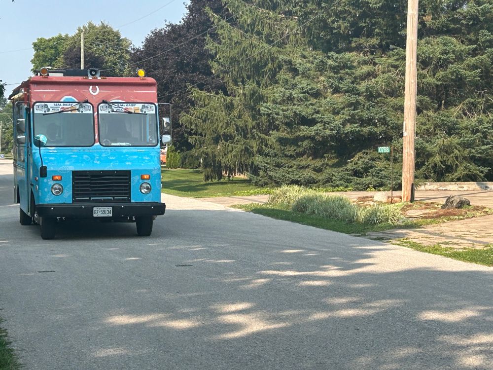 Ice cream truck driving down residential street 