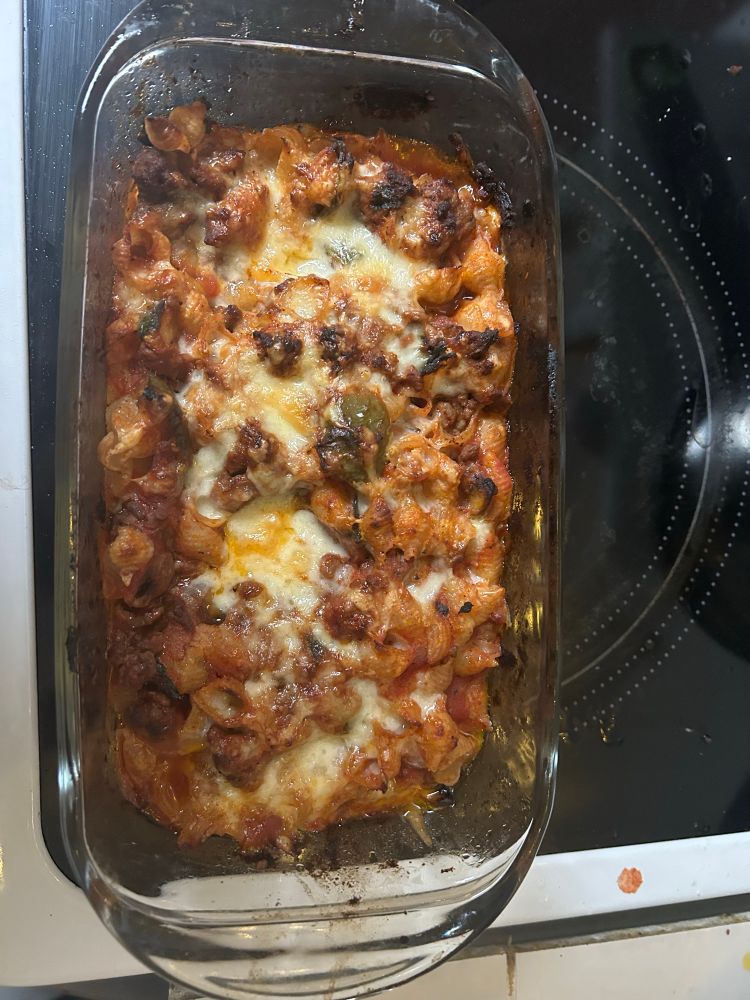 Pasta with cheese on top in a small glass Pyrex dish.