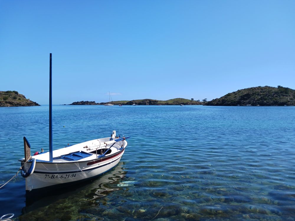 Fischerboot in blauem Wasser, Blauer Himmel. Eine Bucht von Hügeln umrahmt im  Naturhafen. 