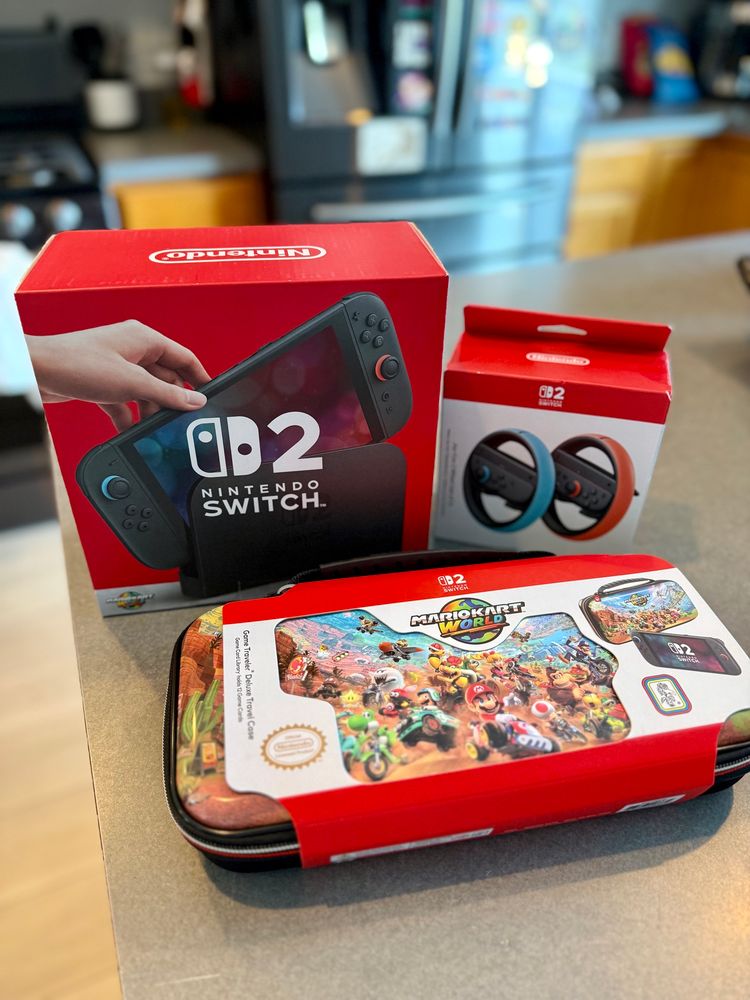 A photo of a Nintendo Switch 2, a case, and a steering wheel accessory.