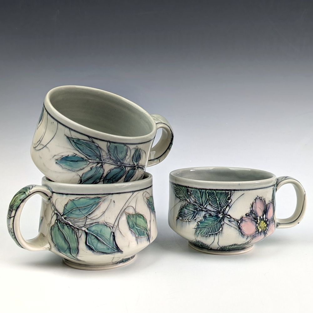 Three mugs with floral and leafy imagery