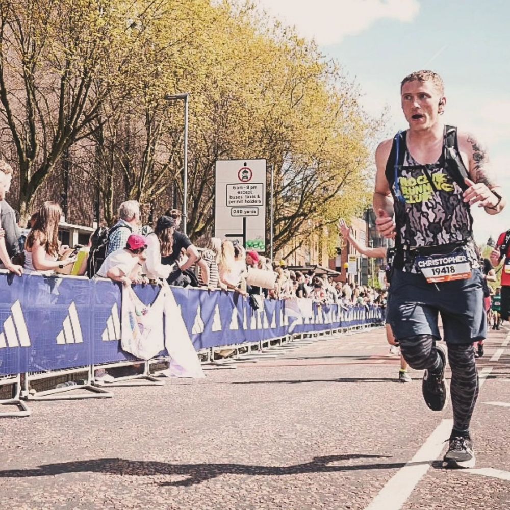 Photo of a very sweaty man going into the last 3km of the 2025 Manchester marathon. The expression on his face screams regret