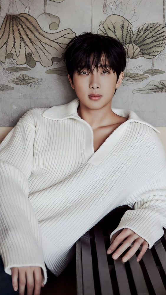 Namjoon during the Indigo promos shoots, dark hair loose and styled over his forehead. He's in an oversized white collared sweater.