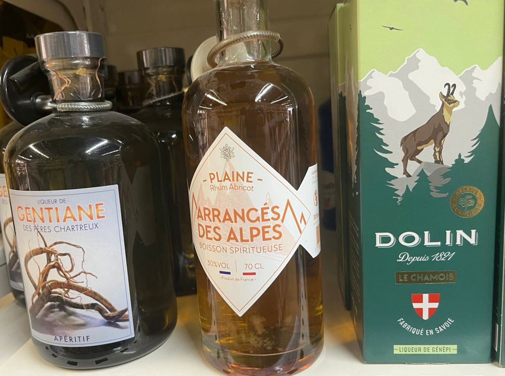 Bouteilles d’alcool dont « Rhum abricot arrangés des Alpes », Gentiane et liqueur de génépi Dolin