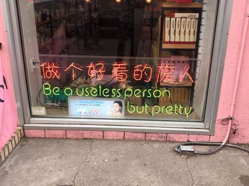 A light up sign says “be a useless person but pretty”