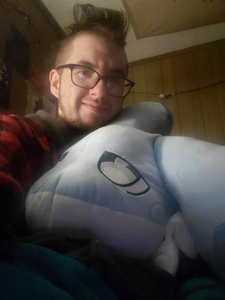 Marz the handsome fellow with a massive Chillet (from palworld) plush, only the head able to fit in his lap 
