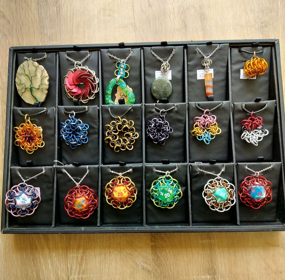 Black jewelry display with various chainmaille pendants