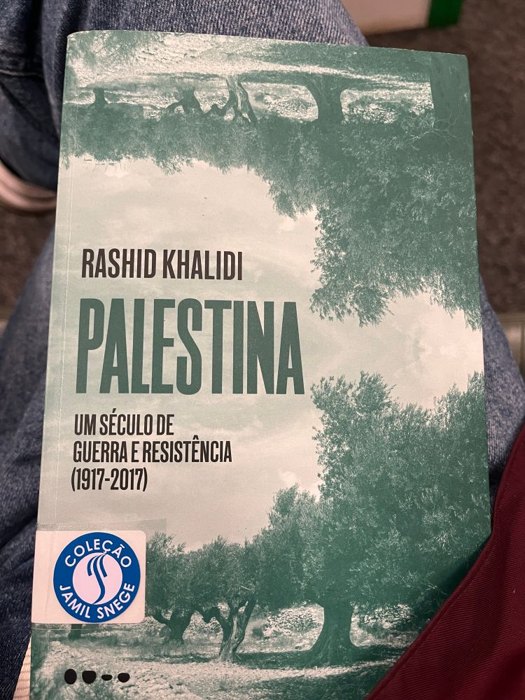Imagem da capa do livro Palestina: um século de guerra e resistência, do autor Rashid Khalid. A capa do livro possuí várias árvores na cor verde e um fundo bege. Possuí um adesivo informando que a obra pertence a coleção Jamil Snege, da Biblioteca Pública do Paraná