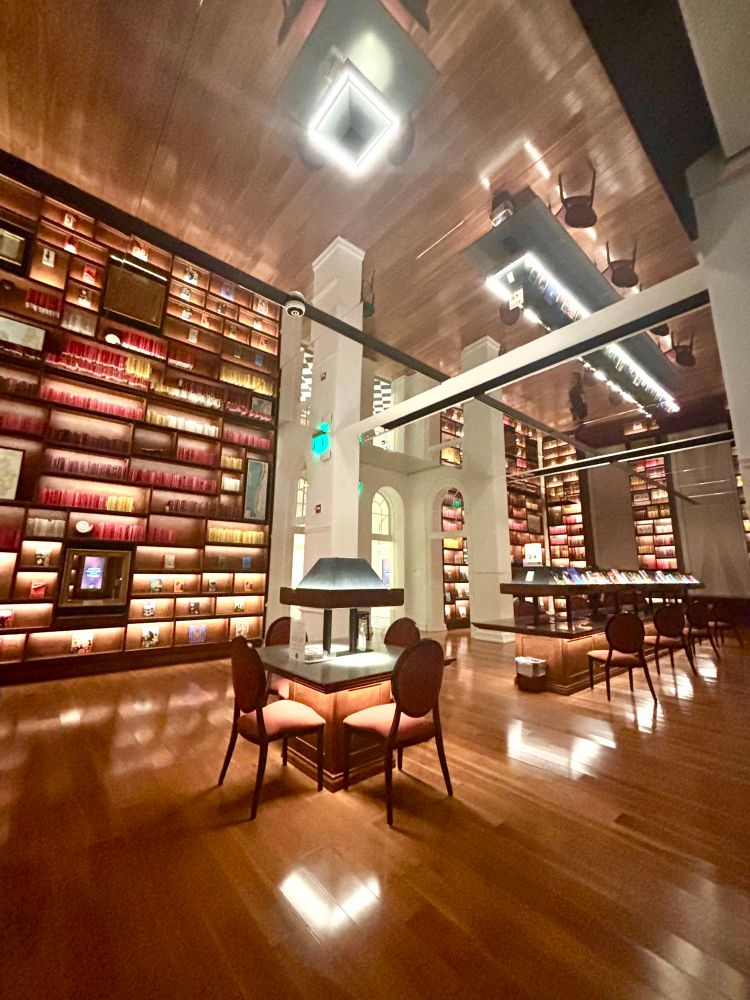 The library at Planet Word, with colorful books lining floor-to-ceiling shelves and several illuminated work stations.