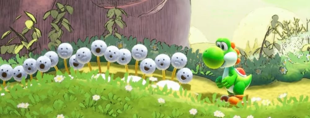 A screenshot from the Nintendo Direct trailer for Yoshi and the Mysterious Book. A green dinosaur-like character called a Yoshi is next to dandelion puffs with faces. The background is a storybook style forest scene